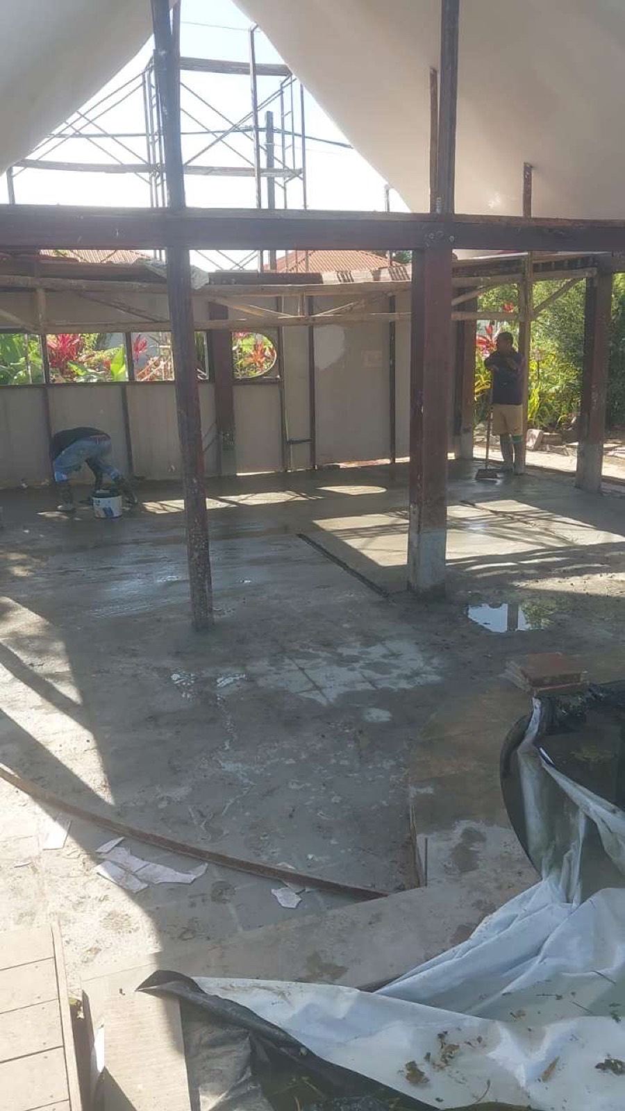 Poolhouse in aanbouw met gestorte vloer en geplaatste staalconstructie.
